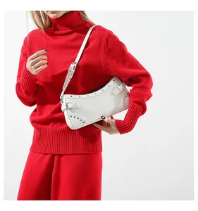 Détail du sac baguette demi-lune en cuir blanc avec clous argentés et boucle de ceinture