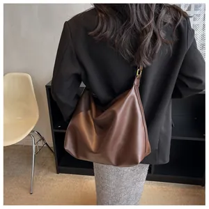 Detailed view of deep brown soft PU leather hobo bag with wide strap and gold buckle
