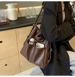 Detail showing the large capacity side pockets of a vintage dark brown shoulder bag
