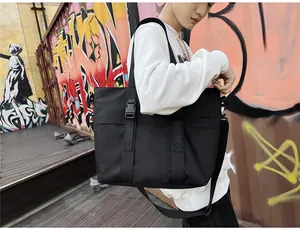 Détail d'un grand sac cabas en tissu Oxford noir avec bandoulière sur le mannequin