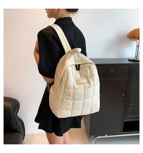 Detailed side view of off-white quilted puffer backpack showing side pocket and texture