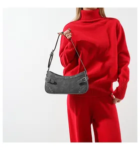 Vue détaillée du sac en denim gris foncé avec boucles argentées et rivets de style rétro