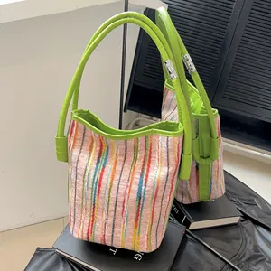 Moderne gestreifte Bucket Bag aus Canvas in Rosa und Grün mit Lederhenkeln und Spiegelung