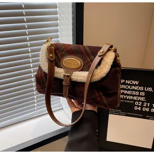 Detail of retro plaid shoulder bag with plush fleece trim and golden metal nameplate