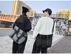 Photo urbaine de mannequins portant de grands sacs de voyage Oxford gris et noirs