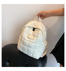 Detail view of the quilted nylon bubble texture on a beige lightweight backpack for women