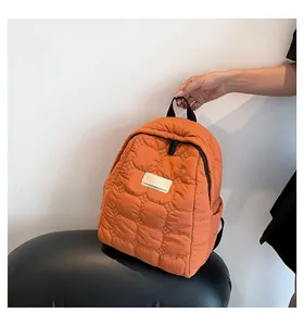Detail of orange quilted waterproof backpack with circular stitching and zipper