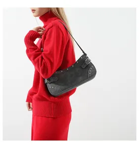 Gros plan sur le sac baguette en denim gris avec rivets argentés et boucles