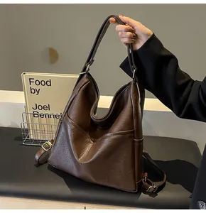 Close-up of deep caramel brown tote bag showing wrinkled leather texture and side pocket
