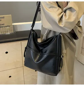 Close-up of the black tote bag texture with diagonal stitching and adjustable metal buckle