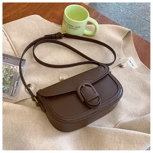 Détails du sac bandoulière en cuir marron foncé avec fermoir métallique rétro et sangle