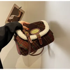 Close-up of vintage plaid wool shoulder bag with white faux shearling trim and brown straps