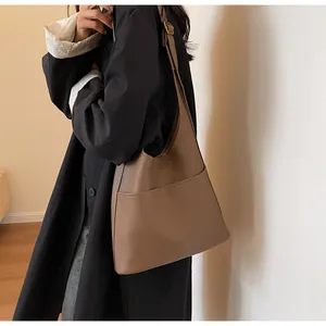 Close-up of brown litchi pattern leather tote bag with wide front pocket and strap
