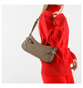 Détail du sac bandoulière marron vintage avec clous argentés et bandoulière réglable