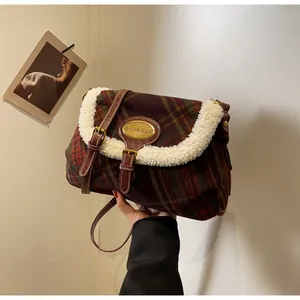 Detail of wool-like plaid crossbody bag with warm faux shearling trim and leather strap
