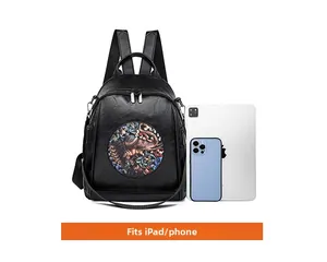 Detail of black faux leather backpack with elephant embroidery next to an iPad for size