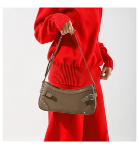 Vue détaillée du sac sous le bras en daim marron avec rivets argentés et boucle en métal