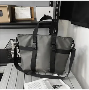 Détail macro du sac cabas gris en tissu oxford avec boucle noire et sangle fonctionnelle