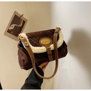 Detail of retro plaid shoulder bag with soft white faux fur trim and gold metal plaque