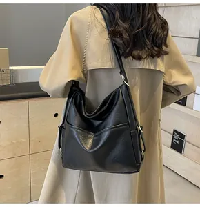 Detailed view of the matte black leather shoulder bag with golden hardware and long strap