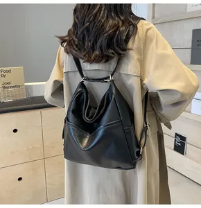 Detailed view of black leather hobo backpack with adjustable metal buckle on beige trench coat