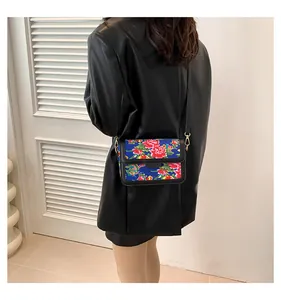 Detail of floral crossbody bag with traditional red peony print and gold metal clasp