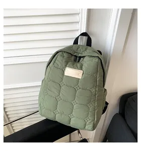 Macro detail of grass green quilted fabric backpack with light-reflecting honeycomb texture