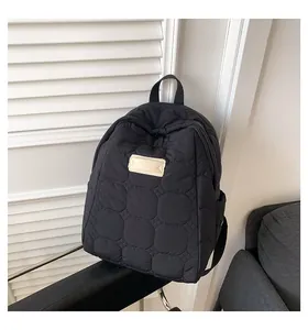 Detail of black quilted puffer backpack showing premium waterproof nylon fabric texture