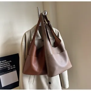 Detail of high-capacity tote bag in pebble leather featuring front slip pocket design