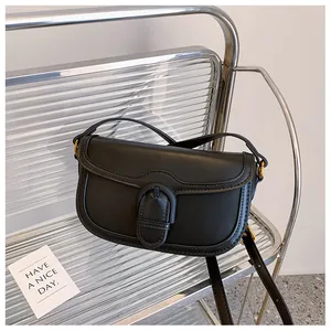 Vue détaillée du sac vintage noir avec boucle sur une chaise métallique moderne