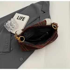 Detailed view of plaid shoulder bag with fleece trim and interior zipper pocket