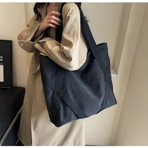 Model-Lifestyle-Foto einer großen schwarzen Canvas-Tragetasche mit Schultergurt