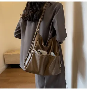 Detail view of large brown vintage tote bag with functional pockets and gold buckle