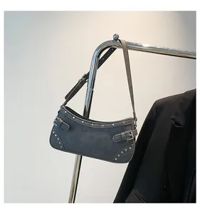 Détail du sac sous le bras rétro gris foncé avec clous argentés sur un cintre en métal