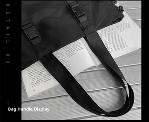 Détail de la poignée en tissu Oxford et boucle en plastique sur un sac de voyage noir