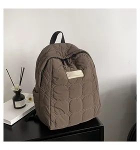 Detail of coffee brown quilted backpack with circular pattern on lightweight nylon fabric