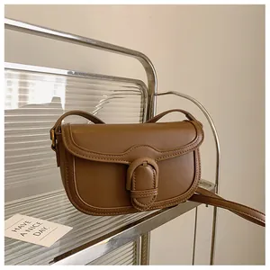 Vue détaillée du sac en cuir marron avec boucle en U métallique et fermeture à rabat
