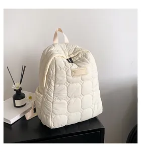 Close-up of beige quilted nylon backpack featuring circular stitching and side pockets