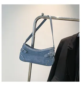 Vue détaillée du sac hobo en denim bleu avec rivets argentés et boucles en métal