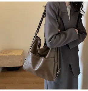 Macro detail of high-capacity brown leather tote bag with functional exterior pockets