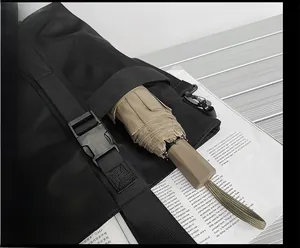 Détail du sac en tissu Oxford montrant une sangle avant fixant un parapluie pliant