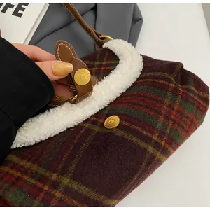 Detail of red plaid pattern with white sherpa trim and golden magnetic buckle on bag