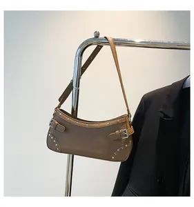 Détail du sac baguette marron avec rivets argentés et boucle métallique élégante