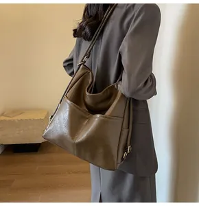 Macro detail of brown leather tote bag with functional pockets and textured finish