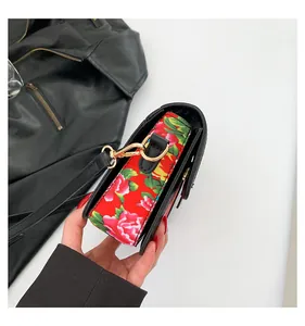 Close-up of the vintage red floral crossbody bag with luxury gold-tone metal buckles