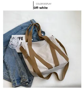 Macro view of off-white canvas tote bag with brown straps and spacious interior detail