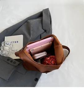 Spacious interior of dark brown leather bucket bag showing tablet and umbrella storage