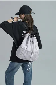 Gros plan sur sac à dos gris clair avec logo de la marque et détails en maille filet