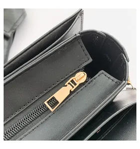 Macro detail of black leather wallet showing gold zipper and precise stitching texture