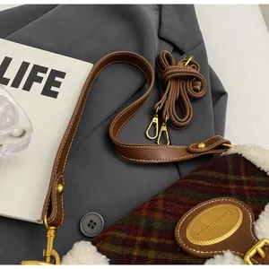 Detail of retro plaid wool crossbody bag with sherpa trim and golden metal hardware